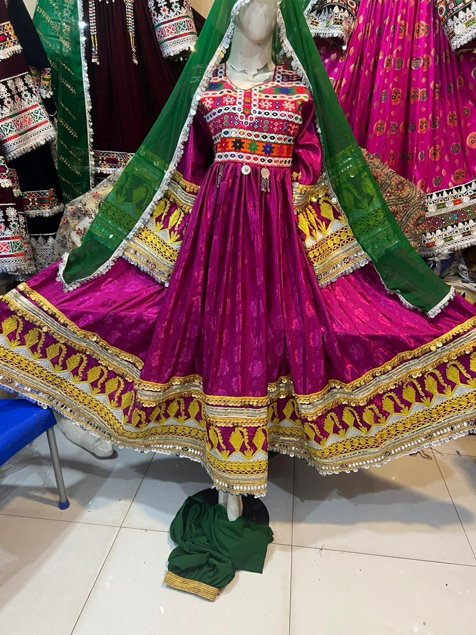 Afghan bridal dress in magenta with green dupatta and mirror work embroidery on mannequin